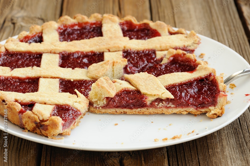 Old fashioned lattice flan with strawberry jam cut with metal sp Old fashioned lattice flan with strawberry jam cut with metal sp