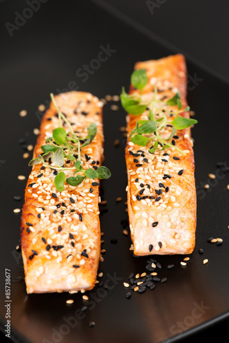 Grilled salmon on black plate vertical