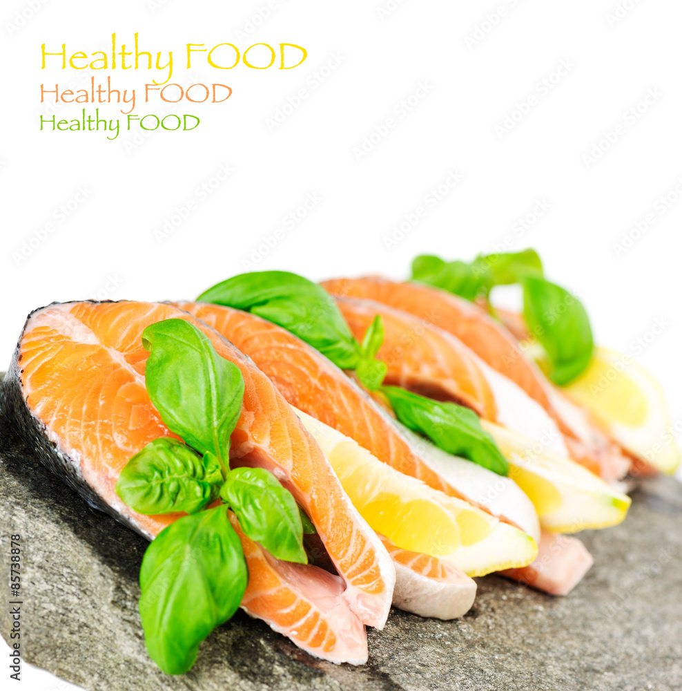 Salmon on stone with basil and lemon isolated on white Salmon on stone with basil and lemon isolated on white