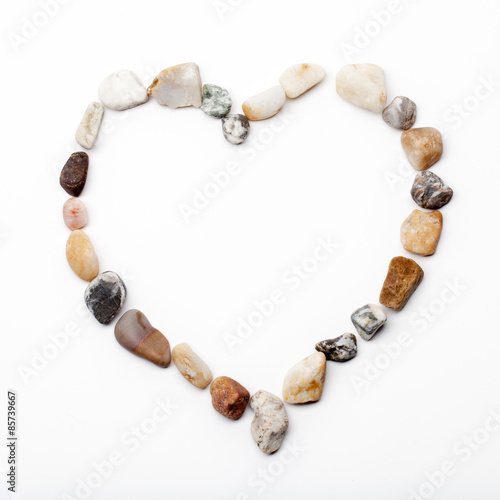 Heart laid out by sea stones on a white background