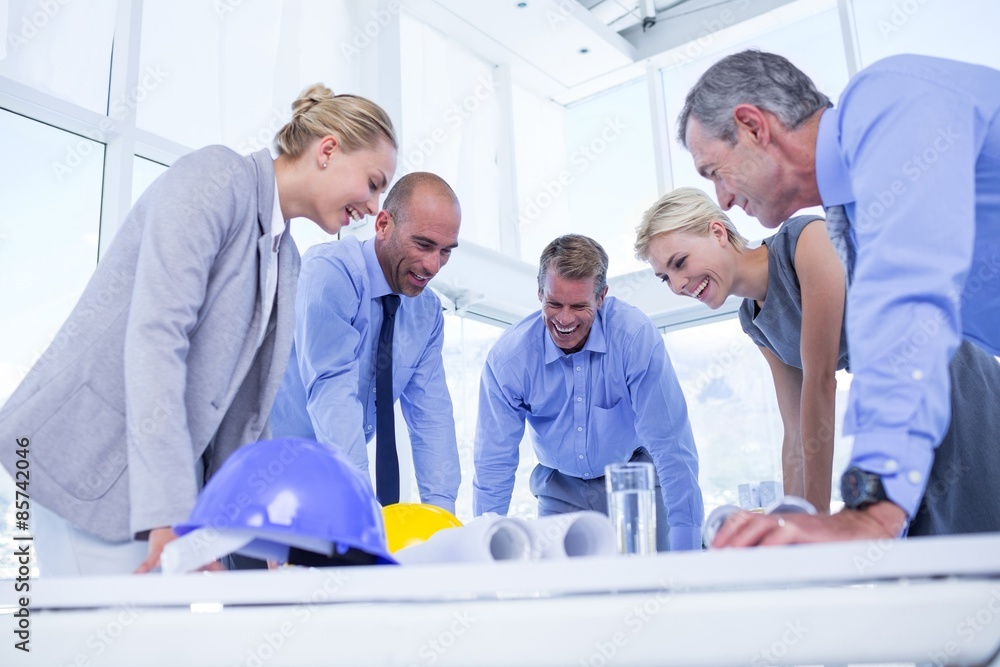 Obraz premium Happy business people looking at construction plan 