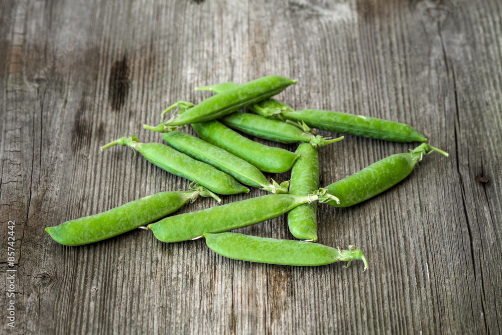 fresh green peas over a rustic wood table fresh green peas over a rustic wood table
