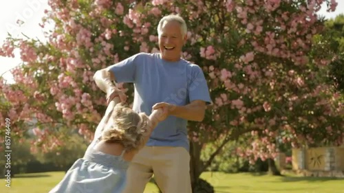 grandfather and granddaughter playing in park