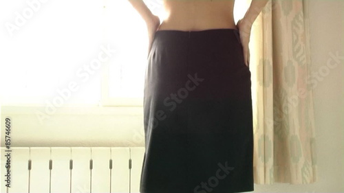 Woman getting dressed in skirt