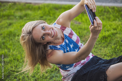 Female model against a lawn in a t-shirt with an American flag a