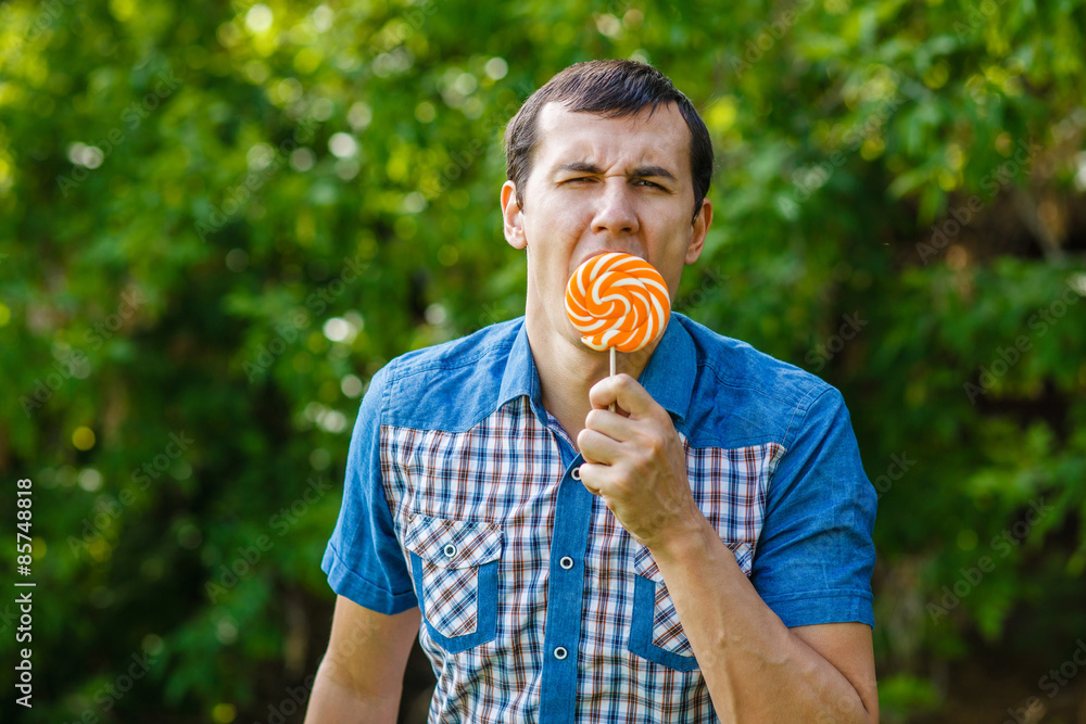 Fototapeta premium The man in the street holding a lollipop on a green background l