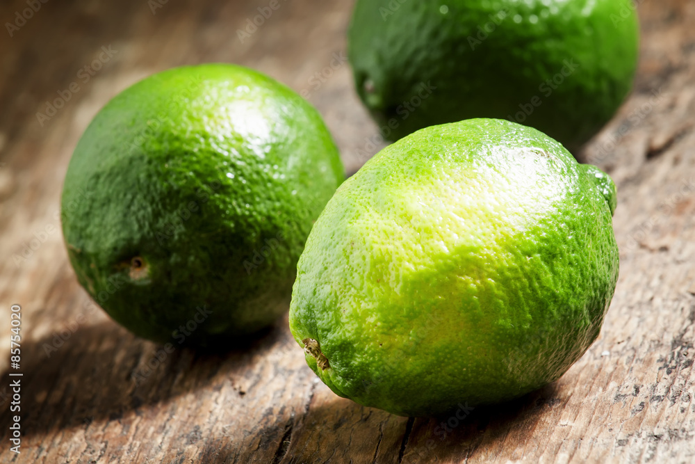 Fresh limes on an old wooden table, selective focus
