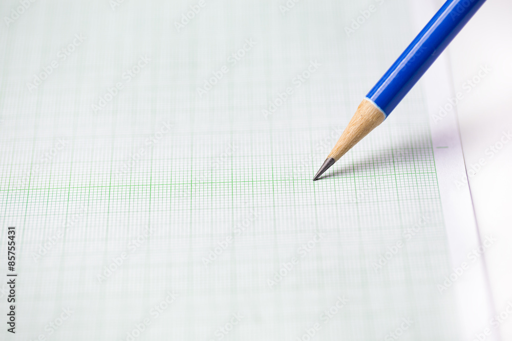 close-up blue pencil on graph paper background close-up blue pencil on graph paper background
