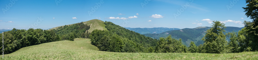 Panoramic view of spring mountains under blue sky