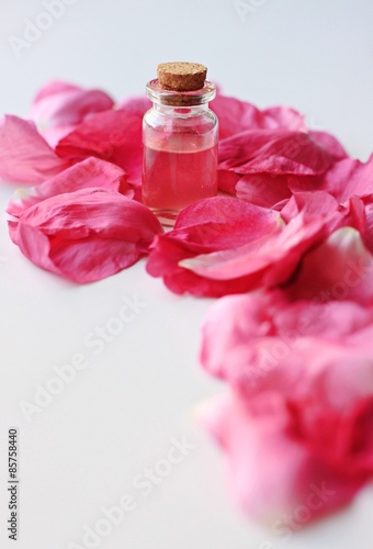 bottle with pink aroma oil fragrance rose petals vertical spa set