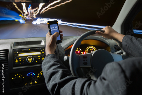 Man using smart phones while driving at night