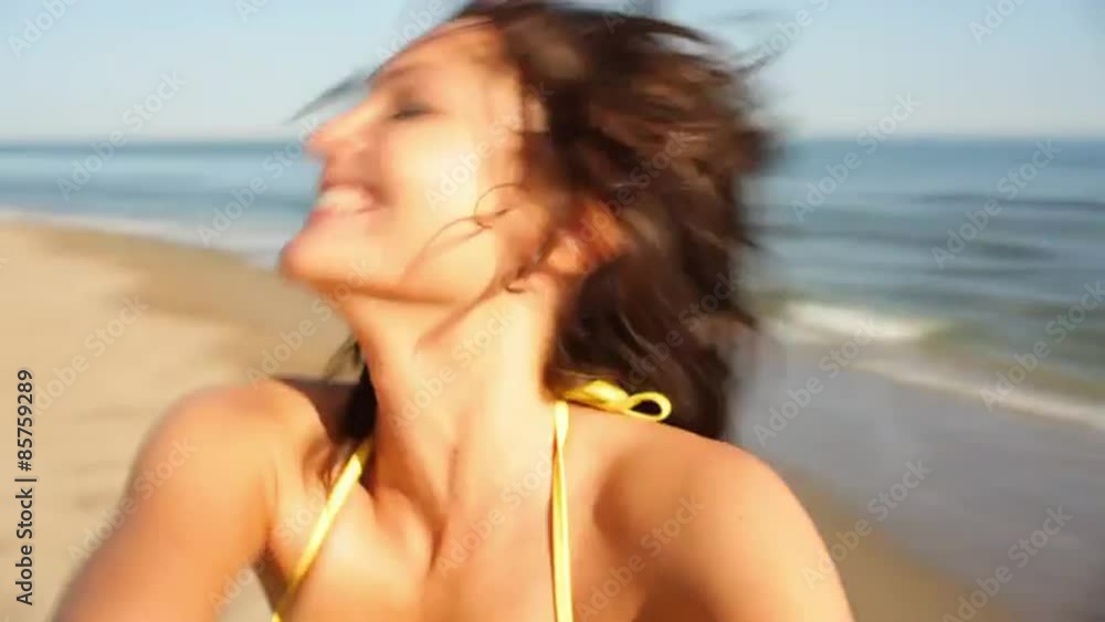 Young woman twirling on beach Young woman twirling on beach