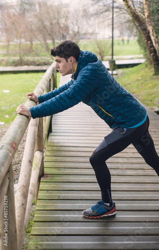 Runner man stretching in a park outdoors