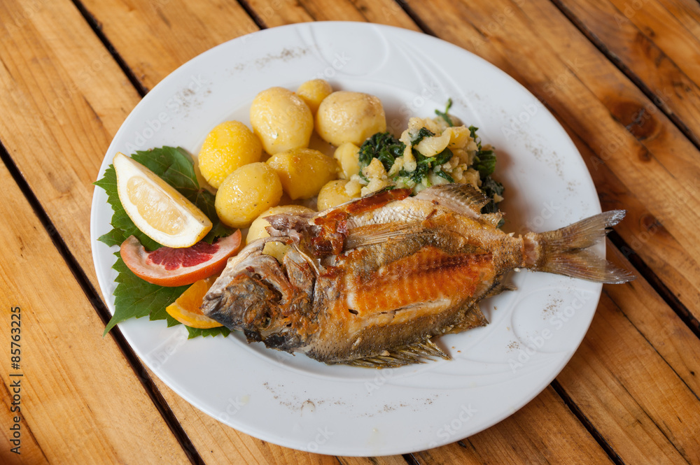 A traditional plate of grilled fish and sides in Croatian restaurant A traditional plate of grilled fish and sides in Croatian restaurant