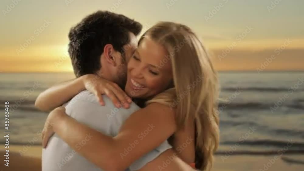 young couple hugging and twirling on beach young couple hugging and twirling on beach