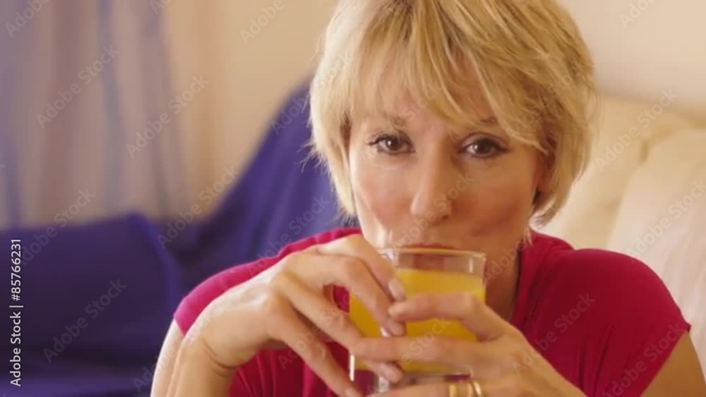 Dolly shot of woman drinking glass of orange juice. Dolly shot of woman drinking glass of orange juice.