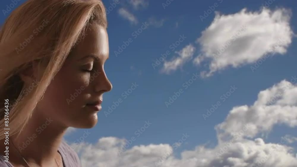 Woman's face with clouds in the background. Woman's face with clouds in the background.
