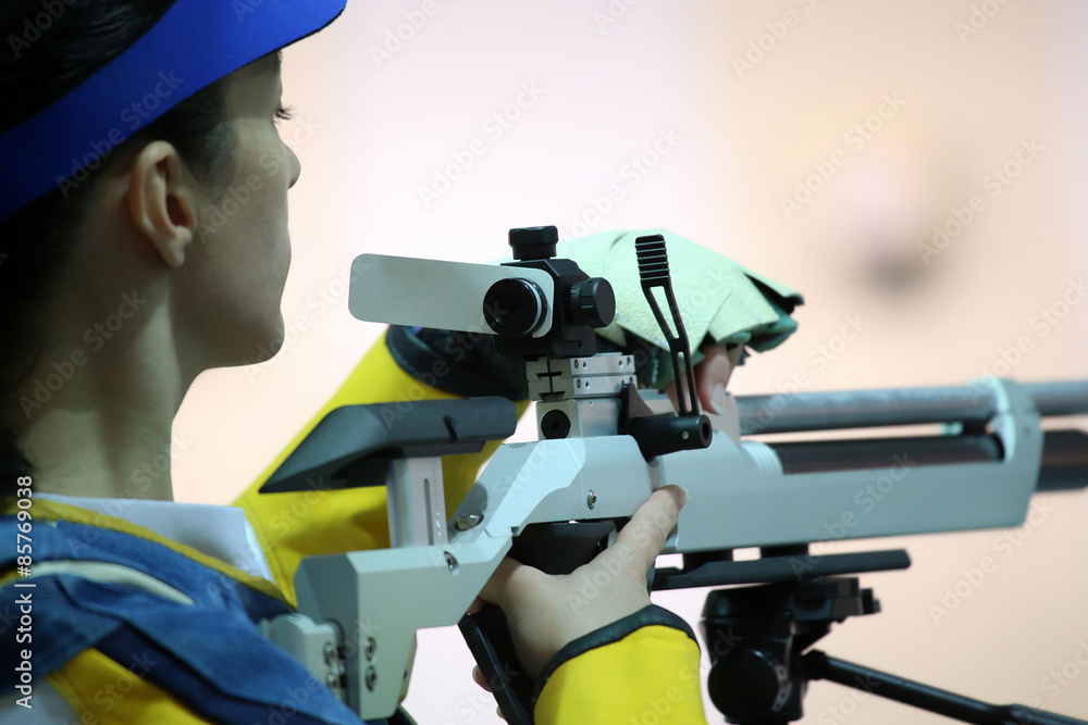 Obraz premium woman aiming a pneumatic air rifle