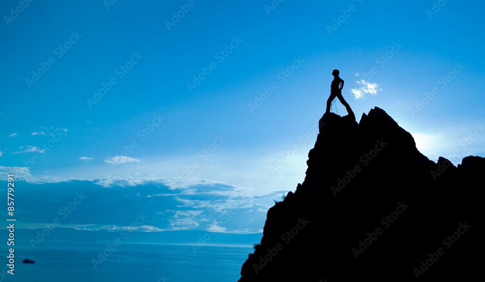 Silhouette of person standing near the top at blue sky