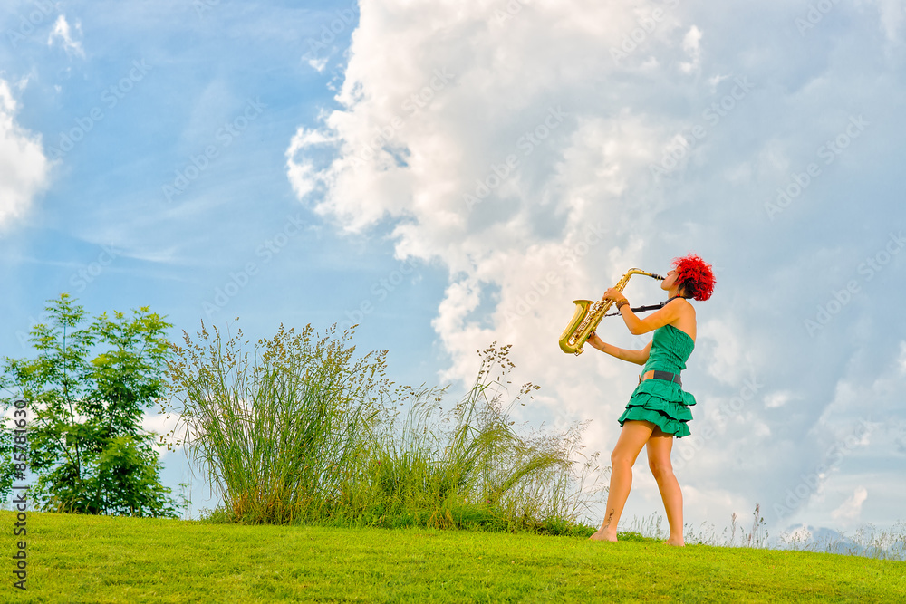 Young saxophonist (woman with the red hair) playing saxophone in Young saxophonist (woman with the red hair) playing saxophone in