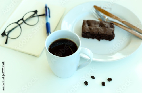 Coffee with blank paper note and glasses and chocolate brownie