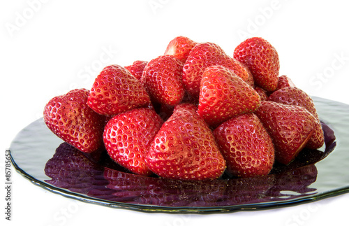 Purple plate full of freshly picked strawberries
