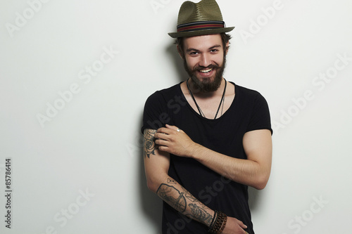 Smiling Hipster boy.handsome man in hat.Brutal bearded man with tattoo