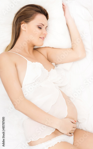 Pretty pregnant woman in a bed