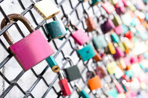 Many love padlocks on fence with selective focus on a blank lock.