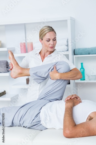 Physiotherapist doing leg massage to her patient