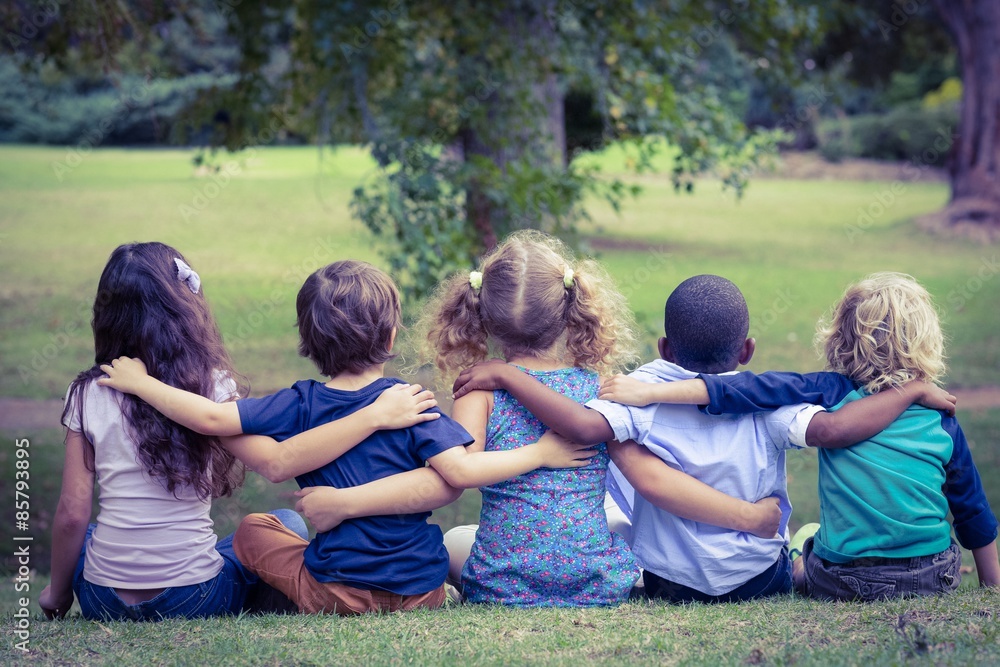 Fototapeta premium Back turned sitting children in the park