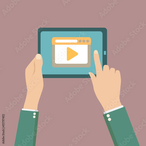 Human hands holding tablet computer with video player on the scr