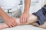 Physiotherapist doing leg massage to his patient