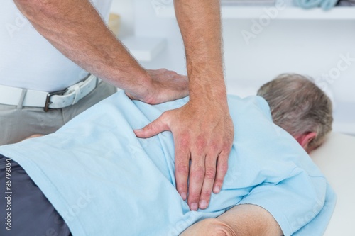 Physiotherapist doing back massage to his patient