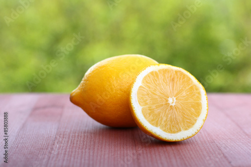 lemon slices on wooden table against green natural background