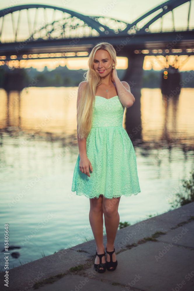 beautiful young woman with waving hair at seafront near river at beautiful young woman with waving hair at seafront near river at