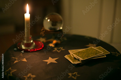 Tavolino da cartomante con tarocchi, candela e sfera di cristallo photo