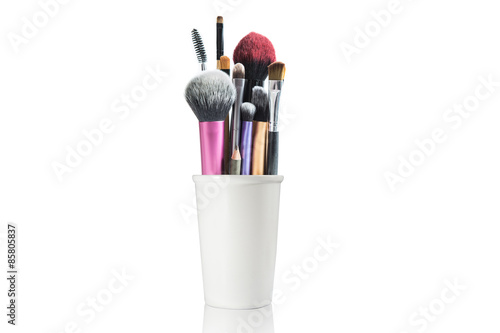 make up brushes in a cup on white background