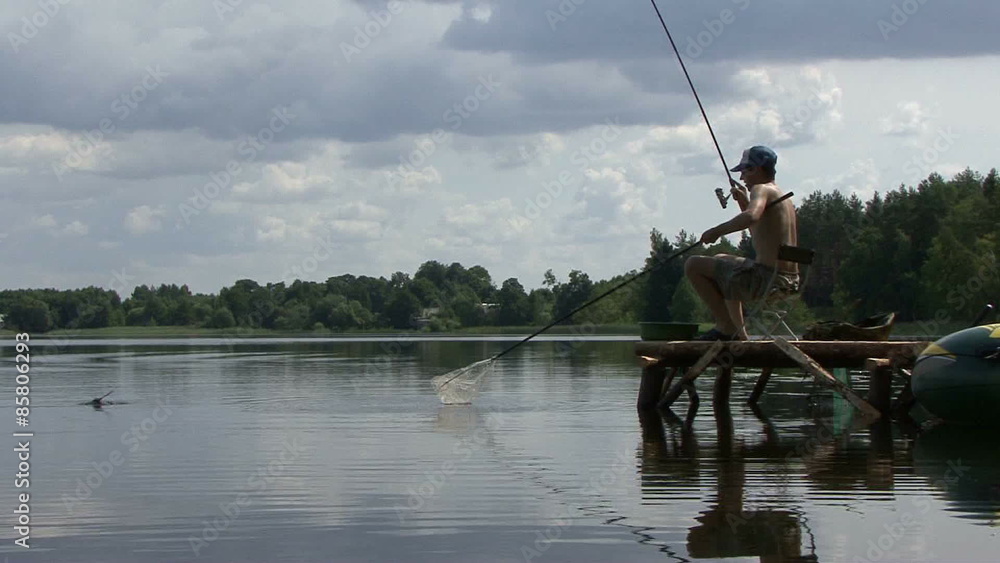Sport fisherman fishing on a river bank Sport fisherman fishing on a river bank