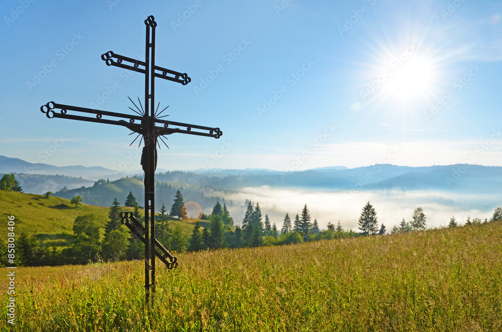 Cross-crucifixion in the field on a sunny day with fog in the mo