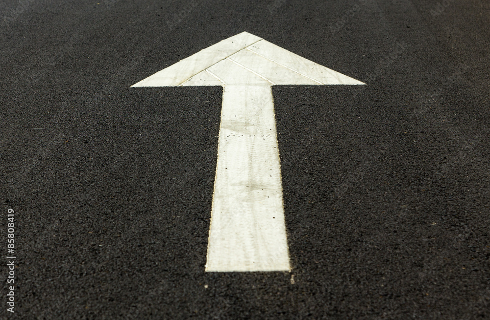 Arrow symbol on asphalt road