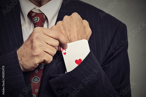 Foto cropped image man hand pulling out a hidden ace from sleeve