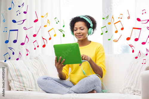 happy african woman with tablet pc and headphones