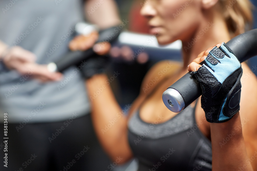 man and woman flexing muscles on gym machine man and woman flexing muscles on gym machine