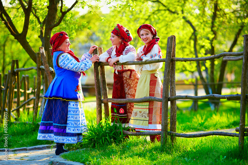 happy ukrainian women, dressed in traditional costumes, talking on the street photo