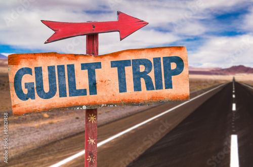 фотографія Guilt Trip sign with road background