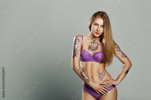 pretty girl with much tattoo in purple lingerie