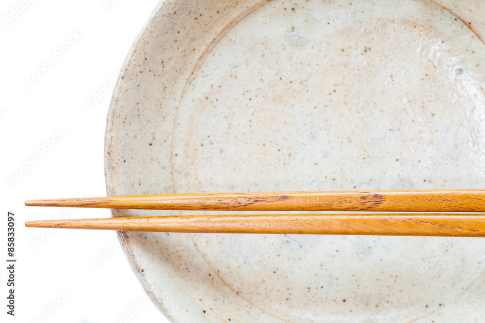 Brown wood chopsticks and white ceramic on white background Brown wood chopsticks and white ceramic on white background