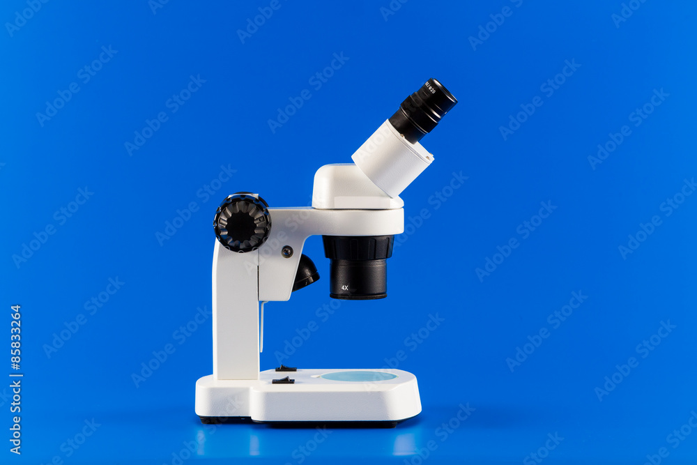 Incident binocular research microscope on blue background Incident binocular research microscope on blue background