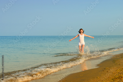 The girl runs on a sandy beach
